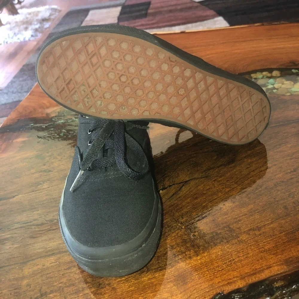 Vans all black kids lace up skateboard shoes.
